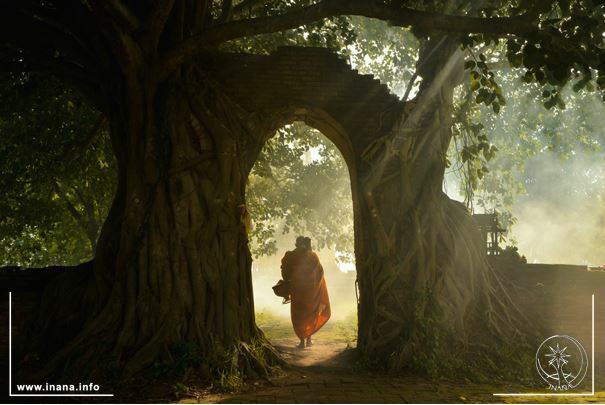 Buddhistischer Mönch durchschreitet ein Tor auf einem alten Pfad