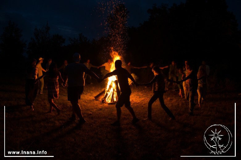 Gruppe tanzt um Feuer